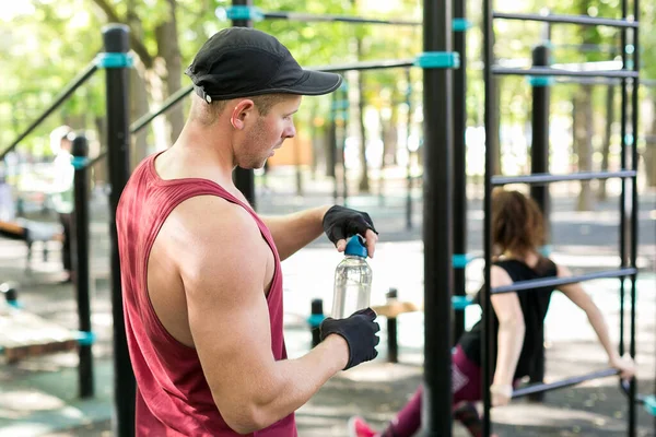 Seitenansicht Des Sportlers Mütze Der Die Flasche Mit Wasser Öffnet — Stockfoto