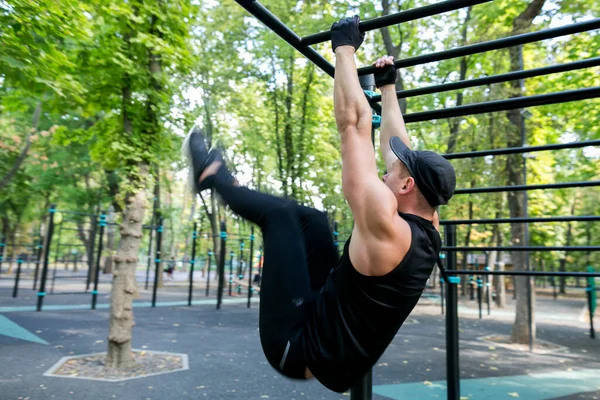 Sportlicher Mann Macht Beinhebungen Während Barren Auf Sportplatz Park Hängt — Stockfoto