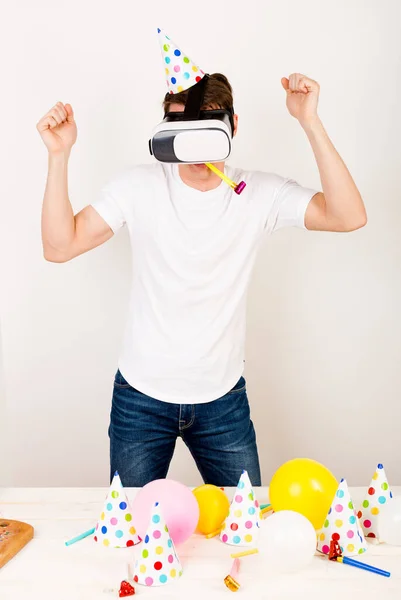 Мужчина Футболке Белом Фоне Праздничной Шляпе Очках Виртуальной Реальности Столом — стоковое фото