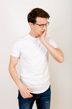 Bir adam güçlü bir negatif duygu ifade ederek elini çenesinin üzerinde tutar. Vücut bozuklukları kavramı. Sağlıksız beslenme ve alışkanlıklar sağlığa zarar verir. 