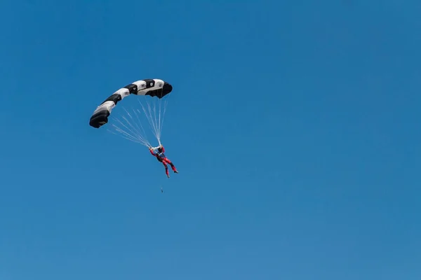 Mavi Gökyüzünde Bulutsuz Renkli Bir Paraşüt Kullanan Insan Silueti Çayırlık — Stok fotoğraf
