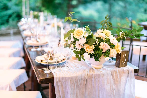 喜庆的户外婚庆餐桌 上铺着天然桌布 精致精致精致 配上全套菜 器具和绿色背景的花朵布置 — 图库照片