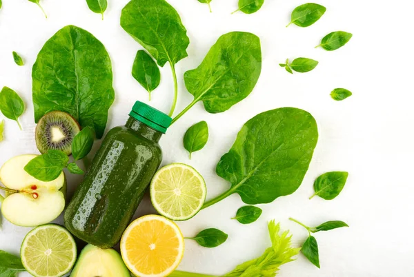 Dilimlenmiş bitkiler, köpükler ve sebzeler arasında yeşil içecekle dolu yaratıcı bir karışım. Diyet içecekleri ve yemek hazırlama konsepti..