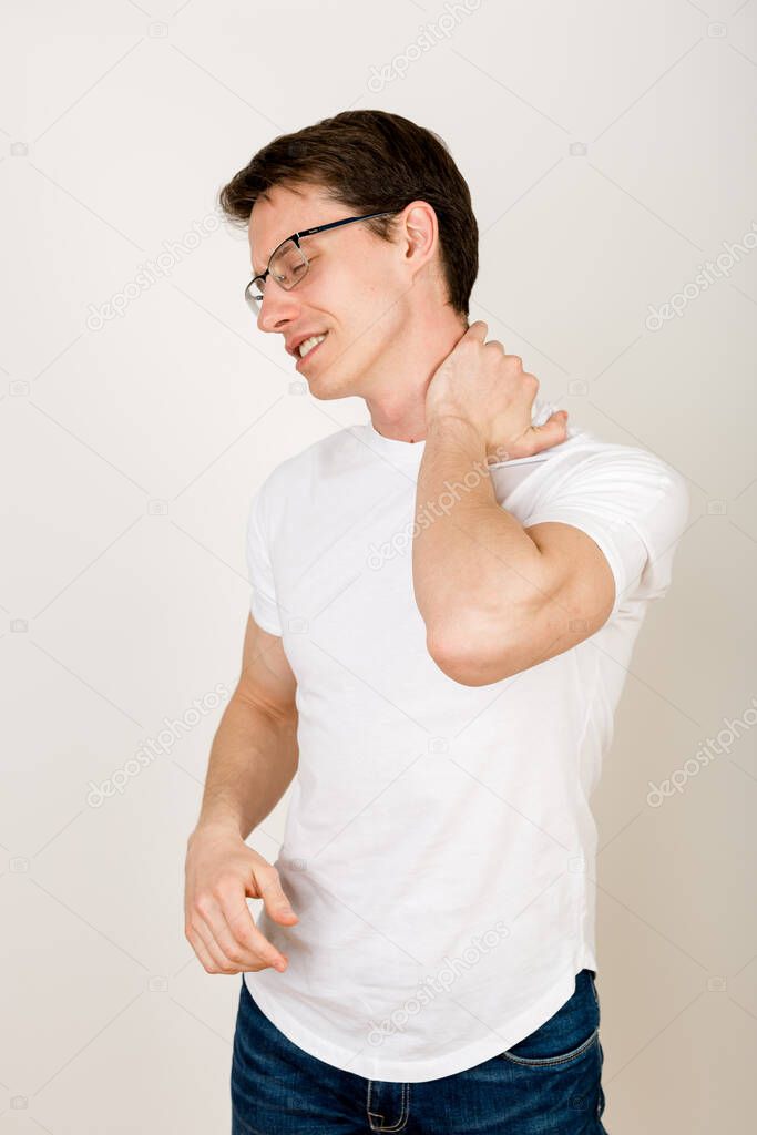 Man massaging his neck The concept of physical pain, body disorders. The harm of constant work with the computer, sedentary lifestyle. Damage to health from unhealthy life and habits. 