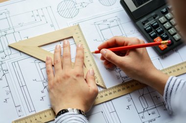 Makine Mühendisi iş başında. Teknik çizimler. Teknik çizimler ve diyagramlar ile kağıt.