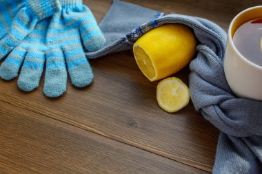 çay limon, eşarp ve eldiven masada.