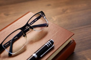 kitap, gözlük ve kalem masanın üzerinde. İş ve eğitim.