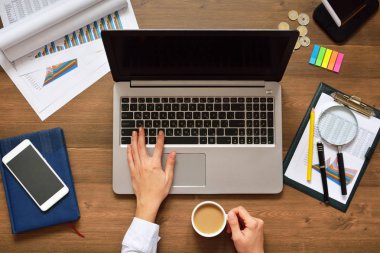 Finansal veriler analiz ediliyor ve bilgisayara güveniliyor. Bir bilgisayarın klavyesinde çalışan erkek eller. Elinde bir fincan kahveyle ara ver.