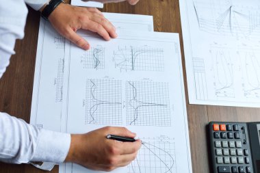 Makine Mühendisi iş başında. Teknik çizimler. Teknik çizimler ve diyagramlar ile kağıt.