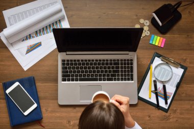 Finansal Kağıt tablolar ve grafikler masanın üzerinde. Finansal verilerin analizi ve bilgisayarda devam ediyor.