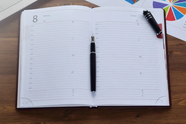 Caderno, caneta, óculos e botões de punho na mesa — Fotografia de Stock