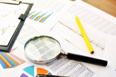 Mali yazdırılan kağıt çizelgeleri, grafikler, diyagramlar, kalem ve Büyüteç camı 