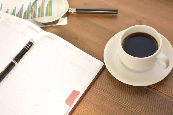 財務書類、グラフィックス、統計計算、木製の背景にコーヒーのマグカップ。コーヒー タイム. — ストック写真