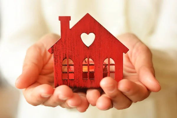 Casa em miniatura quente e acolhedora em mãos femininas. Cuidado e amor . — Fotografia de Stock