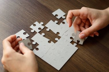 Beyaz bulmacanın elemanlarını birleştiren iş kadını resmi