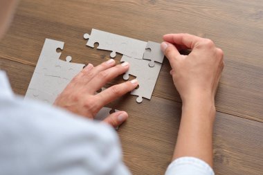 Beyaz bulmacanın elemanlarını birleştiren iş kadını resmi