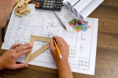 Makine Mühendisi iş başında. Teknik çizimler. Teknik çizimler ve diyagramlar ile kağıt.