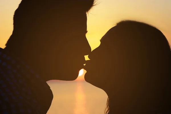 Zwei Liebende (ein Mann und ein Mädchen) küssen sich leidenschaftlich am Strand der Sonne. Liebe und Romantik. — Stockfoto