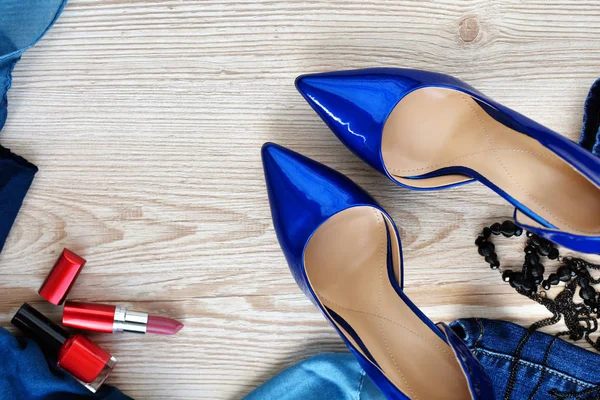 Bayan aksesuarlar (şal, mavi Lake ayakkabılar, parfüm ve boncuk) ahşap arka plan üzerinde 