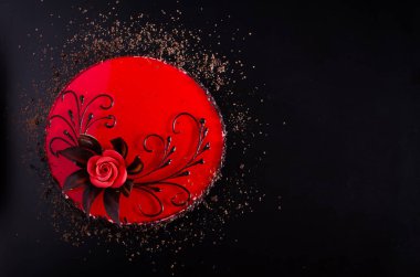 Gül desenli siyah zemin üzerine kırmızı pasta. Üstten Görünüm. Sevgililer günü. Metniniz için boş alan.