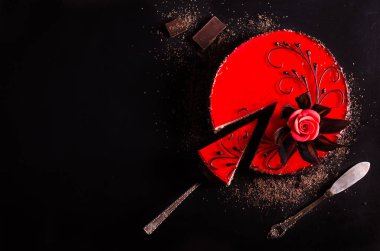 Gül desenli siyah zemin üzerine kırmızı pasta. Üstten Görünüm. Sevgililer günü. Metniniz için boş alan.