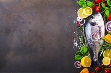 Taze çiğ balık, dorado, çipura limon, otlar, sebzeler ve baharat rustik arka plan üzerinde. Üstten Görünüm. Metniniz için boş alan
