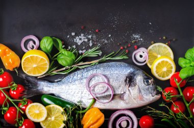 Taze çiğ balık, dorado, çipura limon, otlar, sebzeler ve baharat rustik arka plan üzerinde. Üstten Görünüm.