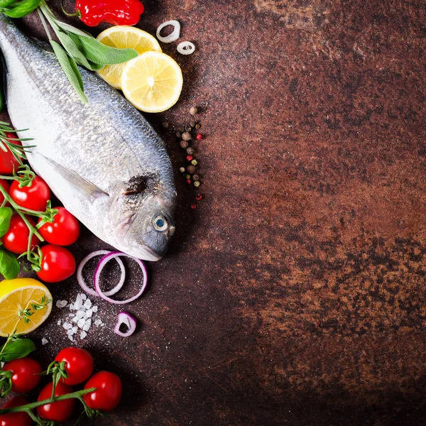 Peixe fresco não cozido, dorado, dourado com limão, ervas, legumes e especiarias em fundo rústico. Vista superior . — Fotografia de Stock