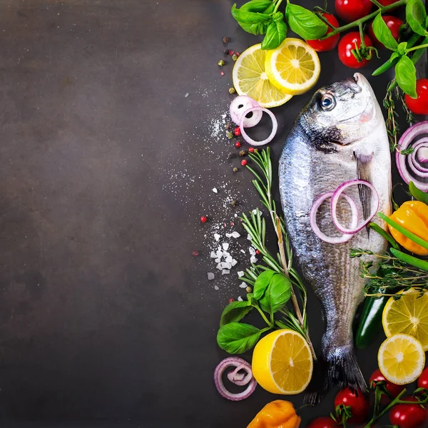 Dorada, peixe fresco com vegetais, limão, ervas, cebola, páprica, tomate cereja, cebola, saltão fundo escuro vintage. Espaço de cópia . — Fotografia de Stock