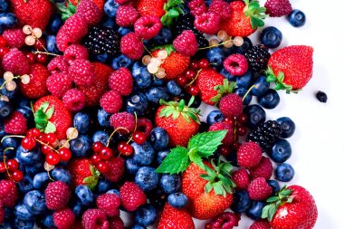 Çilek, yaban mersini, frenk üzümü, nane yaprakları ürün yelpazesine. Gıda çerçeve, sınır tasarlamak. Vejetaryen ve vegan kavramı. Yaz meyveleri arka plan kopya alanı metni ile. Üstten Görünüm.