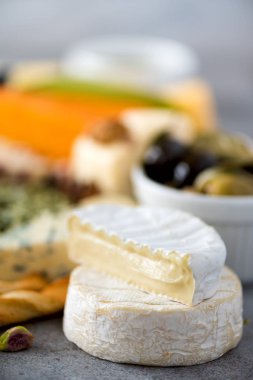 Sert, yarı yumuşak ve yumuşak peynir zeytin, grisini ekmek sopa, Kapari, gri beton artalan üzerinde üzüm ile ürün yelpazesine. Görünümü en çok alanı kopyalayın, yat. Peynir seçimi meze tabağı.