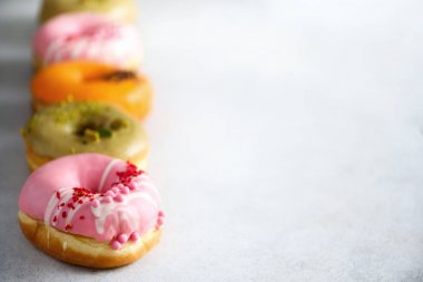 Tatlı ve gri arka plan üzerinde renkli çörekler. Taze pişmiş çörekler. Kopya alanı.