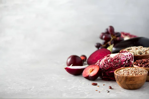 Conceito de comida limpa. Verduras roxas cruas em fundo de concreto cinza. Berinjela violeta, beterraba, couve-flor, feijão roxo, ameixas, cebola, uva, quinoa, arroz. Ingredientes para cozinhar, espaço de cópia — Fotografia de Stock