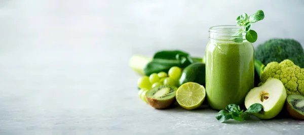 Yeşil sağlık güler yüzlü, lahana yaprakları, limon, elma, kivi, üzüm, muz, avokado, marul ile Cam Kavanoz kupalar. Uzay kopyalayın. RAW, vegan, vejetaryen, alkalin gıda kavramı. Afiş
