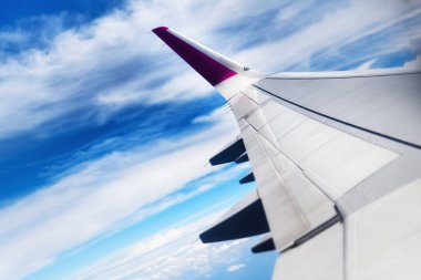 Seyahat kavramı. Gökyüzündeki bulutların üzerinde uçan uçak kanadı. Kopya alanı