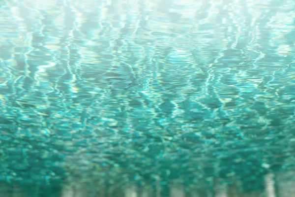 Close up abstract water texture. Turquoise swimming pool water background. Copy space, top view.