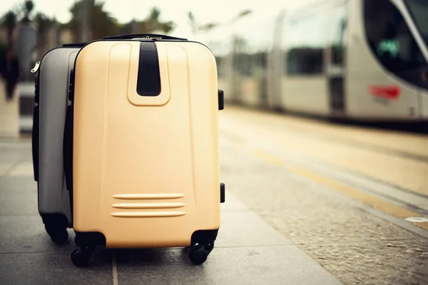 Два валізи, стоячи на залізничному вокзалі проти міському поїзді. Відпочинок та подорожі концепцію. Міський пропуск Light Rail в Єрусалимі. Копія простору, вибіркове фокус — стокове фото