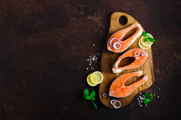 Bife de salmão fresco cru com legumes. Ingredientes para cozinhar em fundo marrom. Espaço para SMS. Dieta e conceito de comida saudável. Banner — Fotografia de Stock