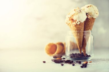 Karamel Sos dondurma waffle koni gri taş zemin üzerine kahve çekirdekleri ile. Yaz gıda kavramı, kopya alanı. Sağlıklı gluten ücretsiz dondurma. Afiş