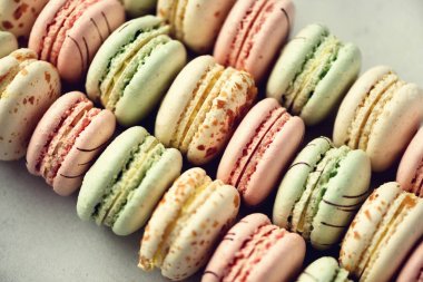 Fransızca macaroons düz renkli yatıyordu. Pastel pembe, yeşil, sarı macarons kopya alanı, üstten görünüm ile renkler. Tatiller ve kutlamalar kavramı. Kadın için tatlı hediye kız