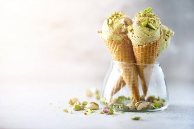 Yeşil dondurma waffle koni gri taş zemin üzerine çikolata ve fıstık fındık ile. Yaz gıda kavramı, kopya alanı. Sağlıklı gluten ücretsiz dondurma.