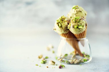 Yeşil dondurma waffle koni gri taş zemin üzerine çikolata ve fıstık fındık ile. Yaz gıda kavramı, kopya alanı. Sağlıklı gluten ücretsiz dondurma.