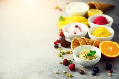 Kase, gözleme koniler, çilek, portakal, mango, gri beton zemin üzerine fıstık krem hayalarına buz. Renkli koleksiyonu, düz yatıyordu, yaz konsepti