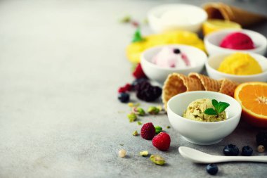 Kase, gözleme koniler, çilek, portakal, mango, gri beton zemin üzerine fıstık krem hayalarına buz. Renkli koleksiyonu, düz yatıyordu, yaz konsepti