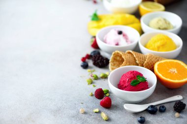 Kase, gözleme koniler, çilek, portakal, mango, gri beton zemin üzerine fıstık krem hayalarına buz. Renkli koleksiyonu, düz yatıyordu, yaz konsepti