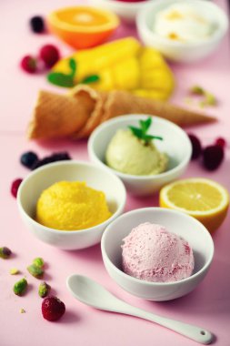 Kase, gözleme koniler, çilek, portakal, mango, limon, nane, pembe shabby chic zemin üzerine Antep fıstığı dondurma topları. Renkli koleksiyonu, yaz konsepti