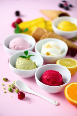 Kase, gözleme koniler, çilek, portakal, mango, limon, nane, pembe shabby chic zemin üzerine Antep fıstığı dondurma topları. Renkli koleksiyonu, yaz konsepti