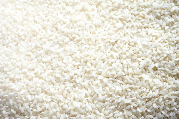 Witte rauwe biologische basmati rijst achtergrond. Voedsel ingrediënt achtergrond. Bovenaanzicht, gezonde levensstijl concept. — Stockfoto