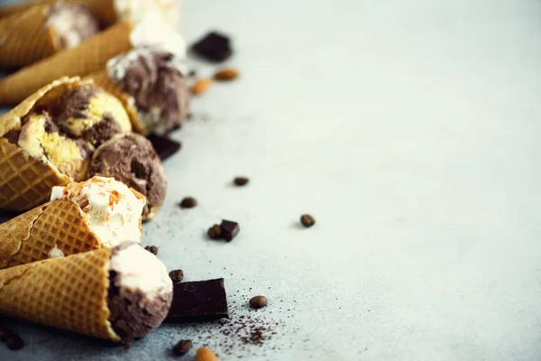 Chocolate and coffee ice cream in waffle cone with coffee beans on grey stone background. Summer food concept, copy space. Healthy gluten free ice-cream. Top view — Stock Photo, Image