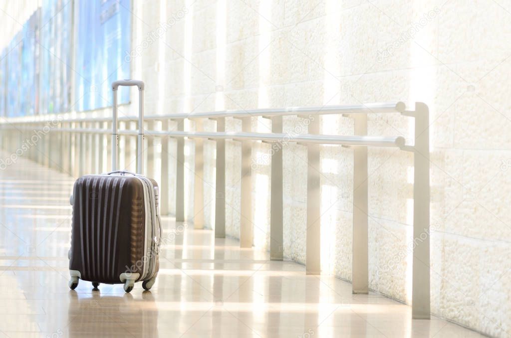 Packed travel suitcase, airport. Summer holiday and vacation concept. Traveler baggage, brown luggage in empty hall interior. Copy space